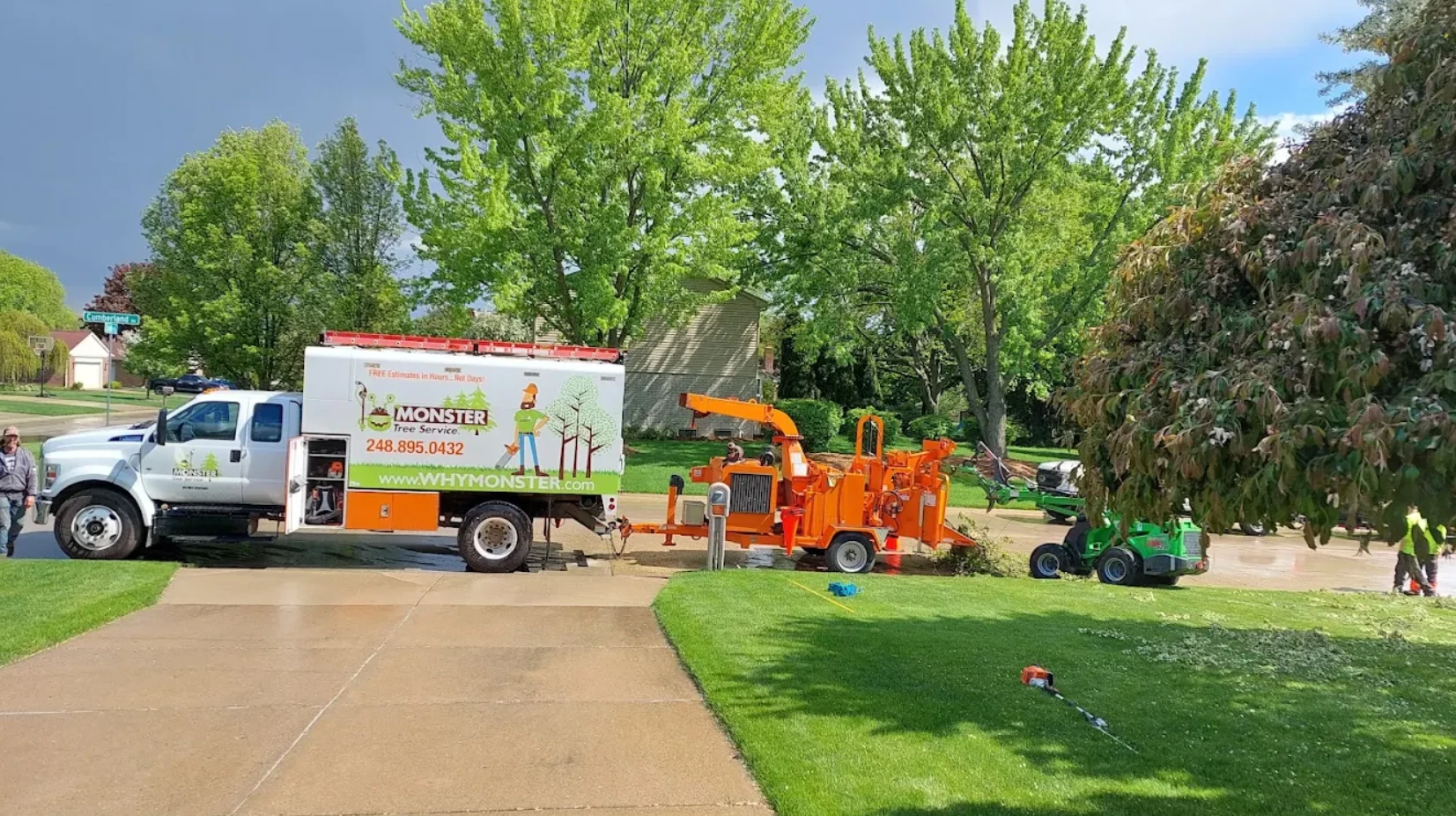 Monster Tree Service truck, chipper, and crew working on a residential street